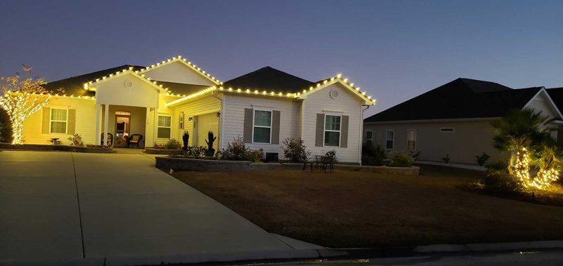 Ranch home with warm white roofline lighting at dusk