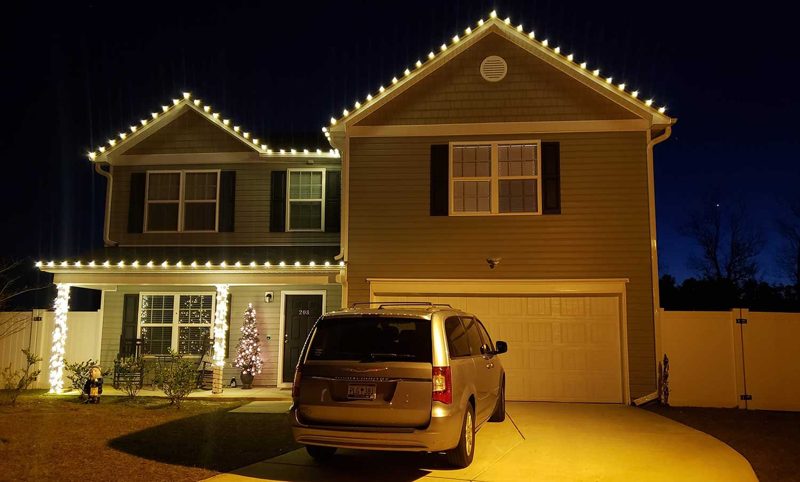 Two-story home with warm white roofline and gable lights