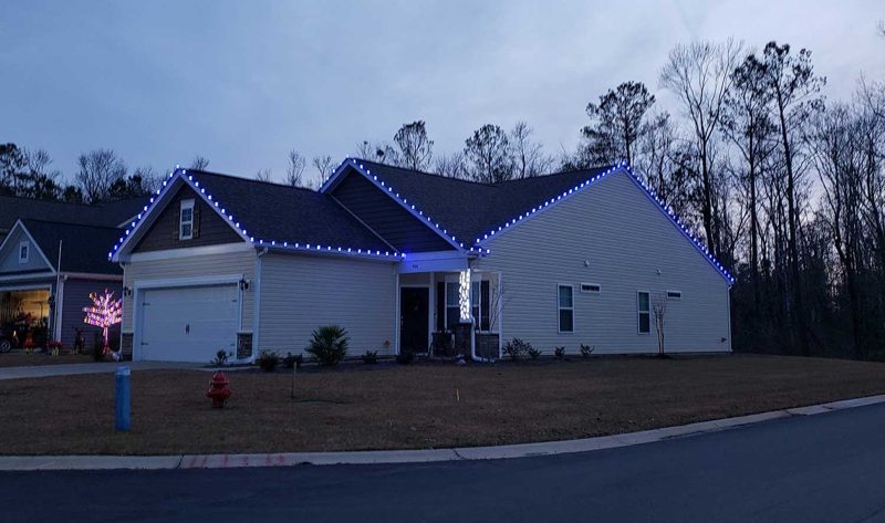 Ranch home with blue and white roofline lights