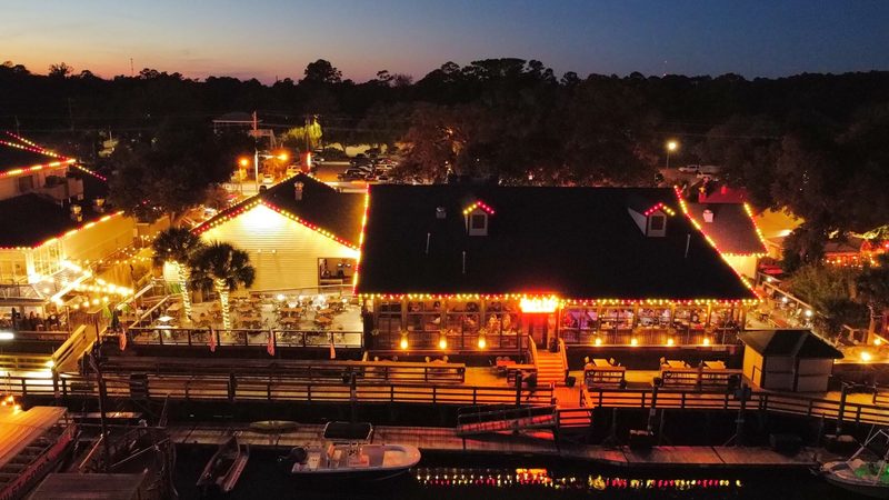 Aerial view of a restaurant patio and docks lit for Christmas