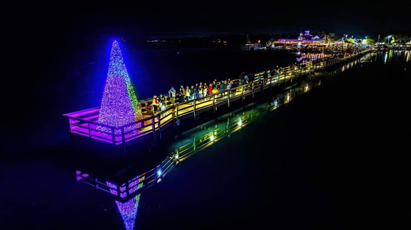 Lit Christmas tree on a dock over the water