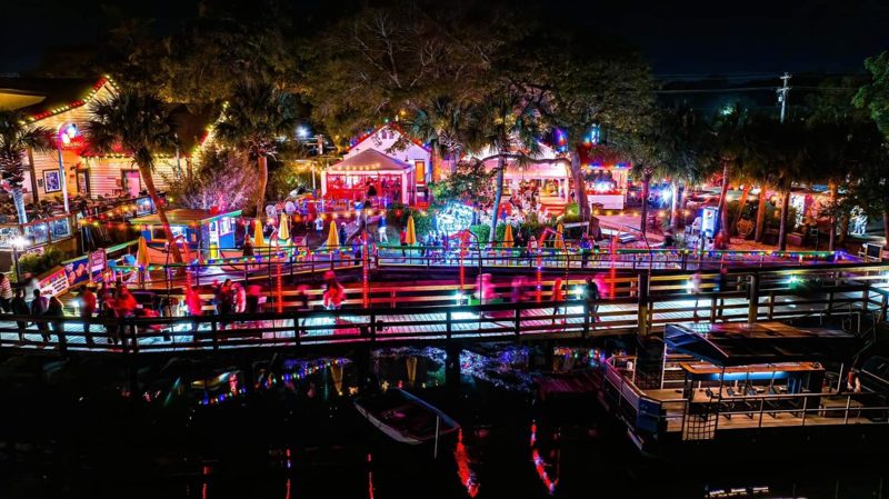 Aerial view of waterfront restaurants with holiday lighting