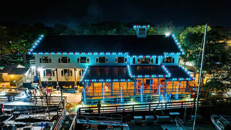 Waterfront building outlined in blue and warm white lights