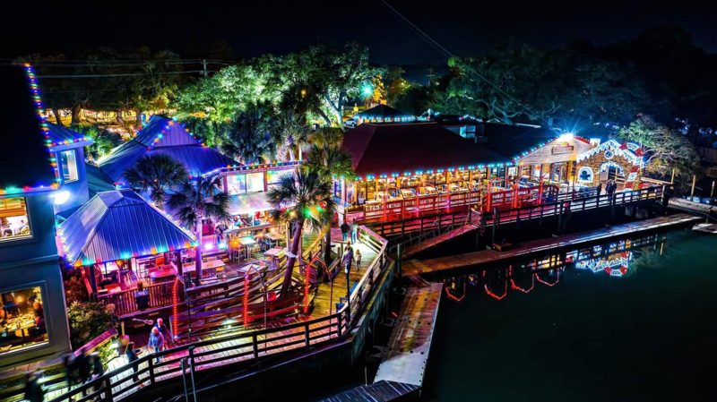 Waterfront restaurant with red and warm white lights at night