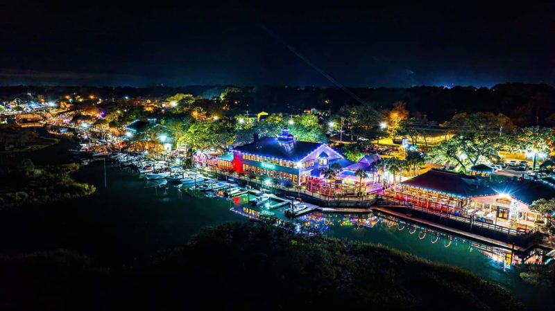 Aerial view of a lit waterfront restaurant district