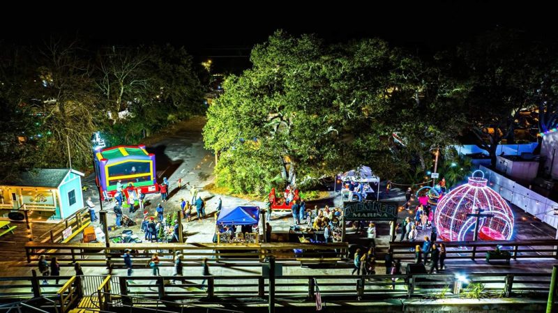 Aerial view of a holiday event under lit oak trees