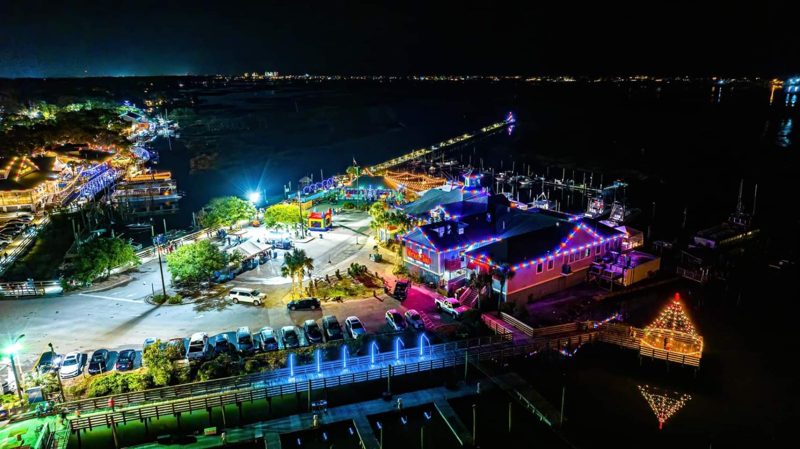 Aerial view of waterfront restaurants and docks lit for Christmas